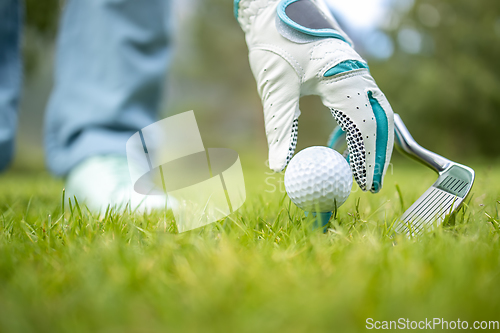 Image of Hand in glove placing golf ball on tee