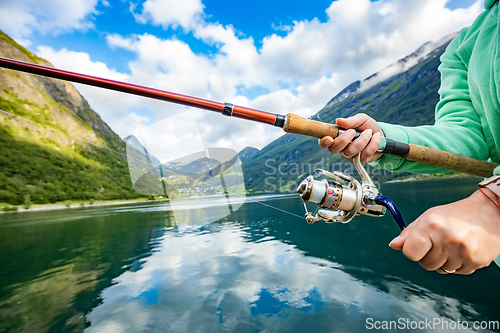 Image of Woman fishing on Fishing rod spinning in Norway.