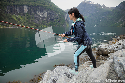 Image of Woman fishing on Fishing rod spinning in Norway.