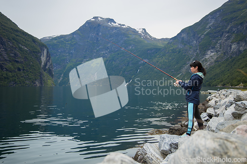 Image of Woman fishing on Fishing rod spinning in Norway.