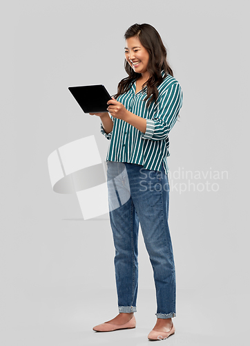 Image of happy asian woman using tablet computer