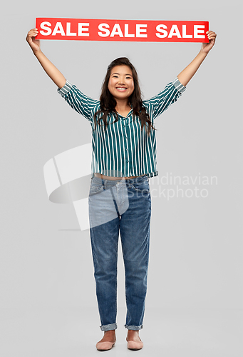 Image of happy smiling young asian woman with sale banner