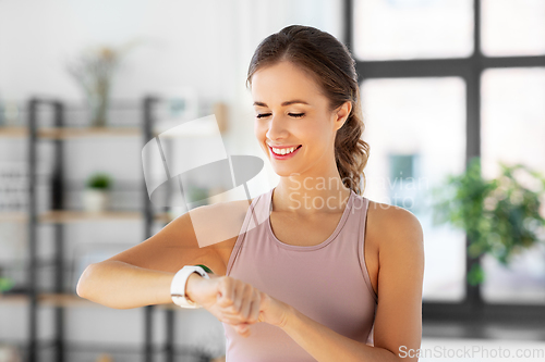 Image of woman with smart watch exercising at home