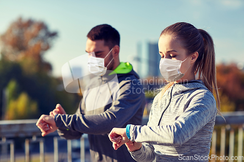 Image of couple in masks running over city highway bridge