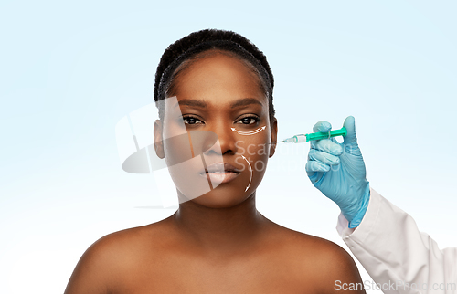 Image of woman and plastic surgeon's hand with syringe