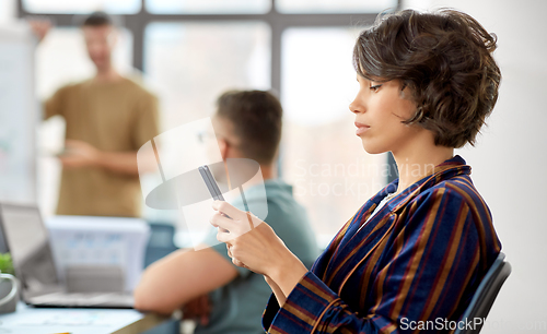 Image of woman with smartphone at office conference