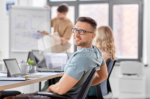 Image of happy smiling man in glasses at office conference