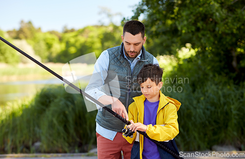 Image of father and son fishing on river