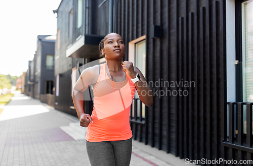 Image of young african american woman running in city