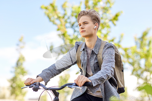 Image of student boy with bag and earphones riding bicycle