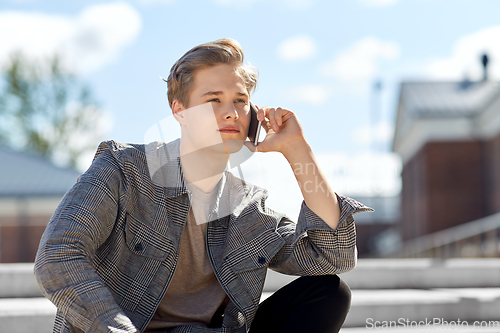 Image of teenage boy calling on smartphone in city