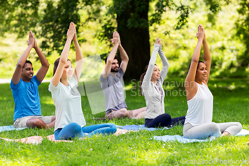 Image of group of happy people doing yoga at summer park