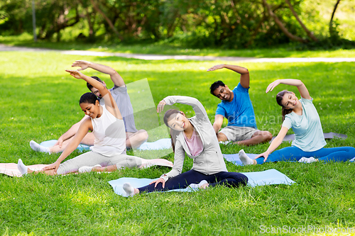 Image of group of people exercising at summer park