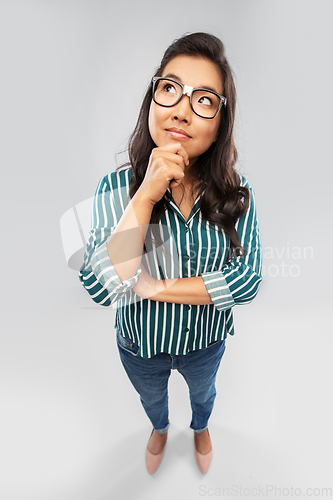 Image of asian woman in glasses looking up and thinking