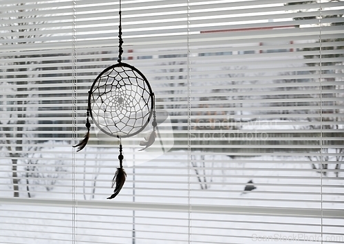 Image of dream catcher on bedroom window and open blinds