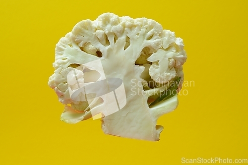 Image of section of a head of cauliflower on a yellow backdrop