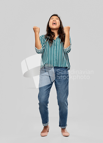 Image of happy young asian woman celebrating success