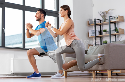 Image of couple exercising and doing lunge at home