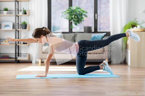 Image of young woman exercising and doing sports at home
