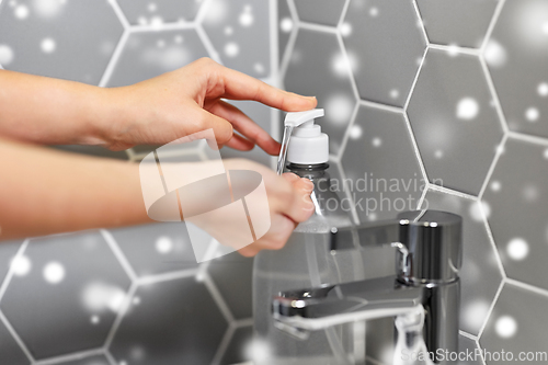 Image of close up of woman washing hands with liquid soap