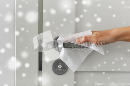 Image of hand cleaning door handle with antiseptic wet wipe