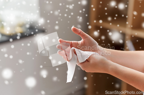 Image of woman cleaning hands with antiseptic wet wipe