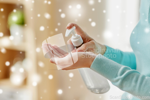 Image of close up of woman applying hand sanitizer