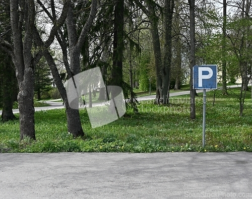 Image of empty parking and parking sign, deadpan photography