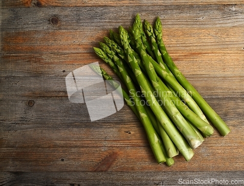 Image of a bundle of asparagus on a wooden background with room for text