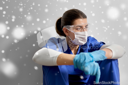 Image of sad doctor or nurse in goggles and face mask