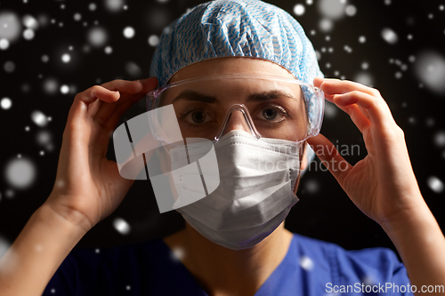 Image of female doctor or nurse in goggles and face mask