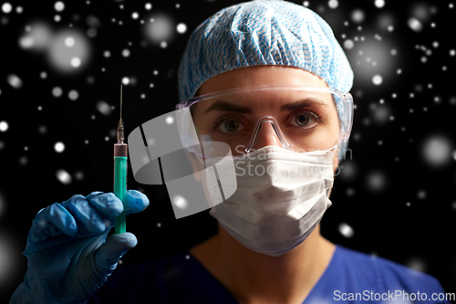 Image of doctor in face mask and goggles holding syringe