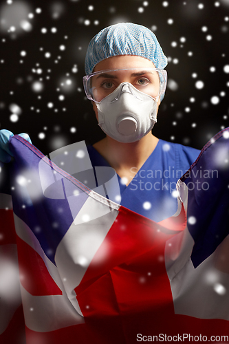 Image of doctor in goggles and mask holding flag of america