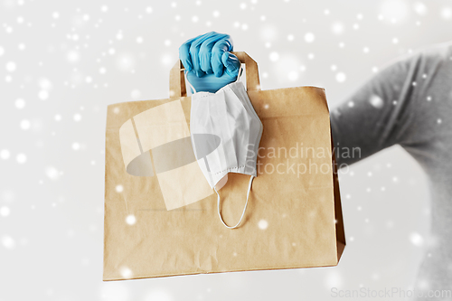 Image of woman with shopping bag, face mask and gloves