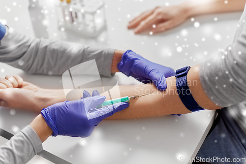 Image of doctor taking blood for test from patient's hand