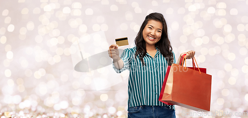 Image of asian woman with shopping bags and credit card