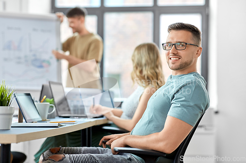 Image of happy smiling man in glasses at office conference