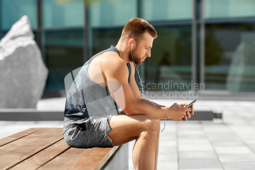 Image of young athlete man with earphones and smartphone