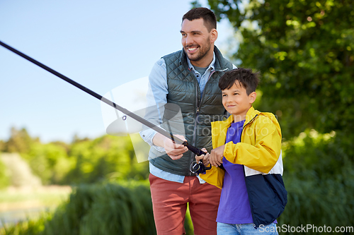 Image of happy smiling father and son fishing on river