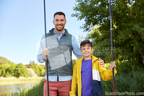 Image of happy smiling father and son fishing on river