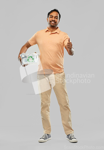 Image of smiling young indian man sorting metallic waste