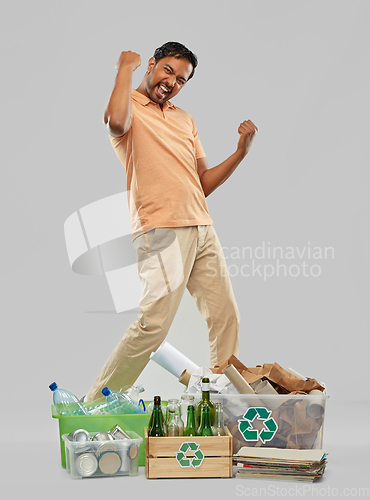 Image of smiling man sorting paper, glass and plastic waste