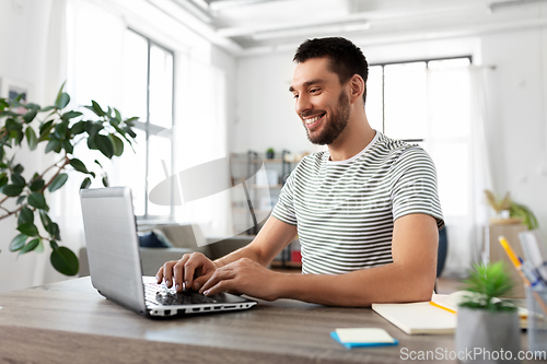 Image of man with laptop working at home office