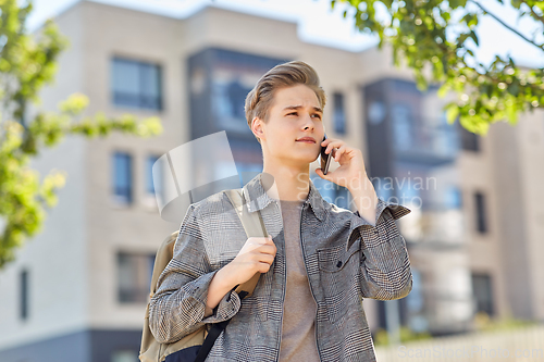 Image of teenage student boy calling on smartphone in city