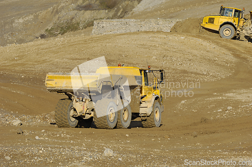 Image of Yellow dump truck working in gravel pit