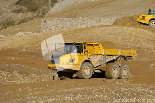 Image of Yellow dump truck working in gravel pit