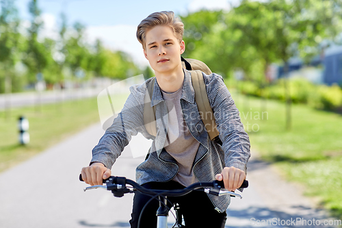 Image of young man riding bicycle on city street