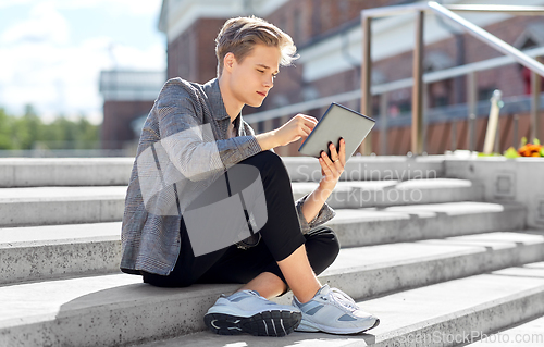 Image of young manor teenage boy with tablet pc in city