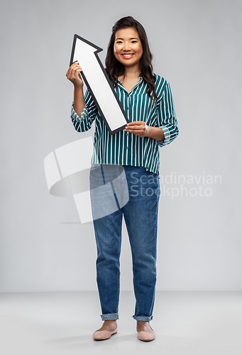 Image of happy smiling asian woman with arrow pointing up