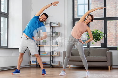 Image of happy couple exercising at home